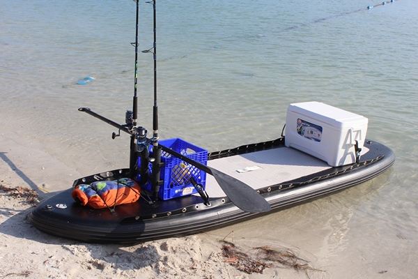 Inflatable SUP set up for fishing with fishing rod, cooler, etc.